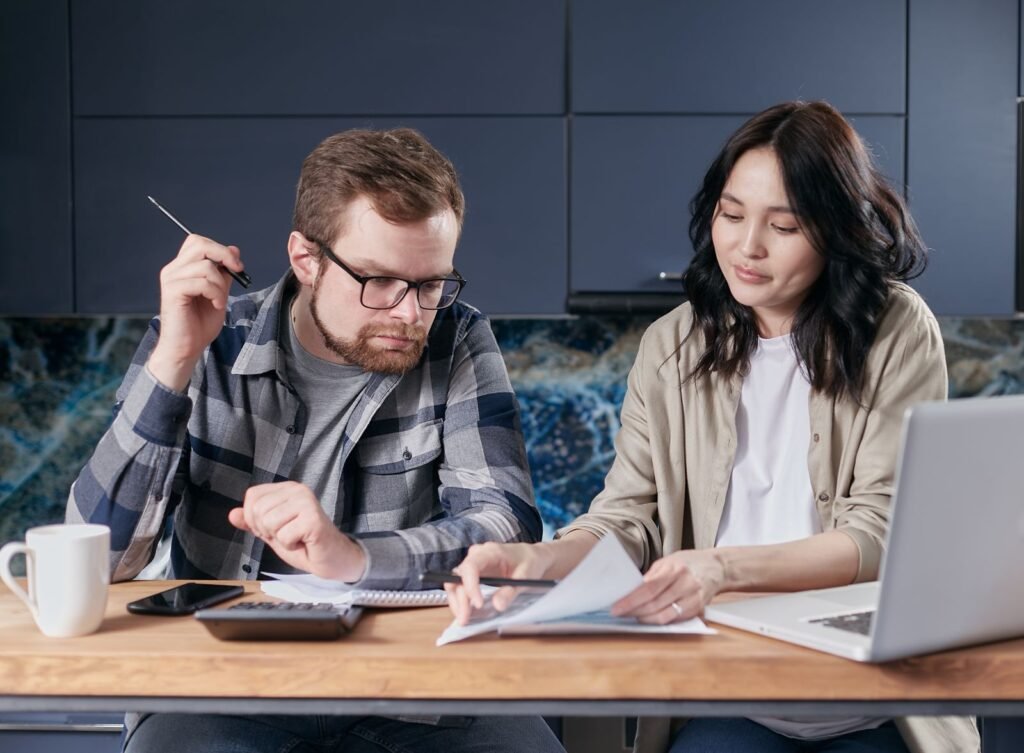 Een stel bespreekt een plan en budget met een rekenmachine — sfeerbeeld