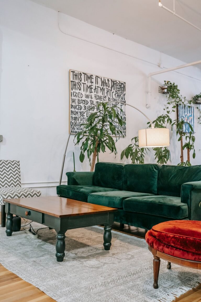 Een woonkamer met een groene bank, planten en houten meubels — sfeerbeeld
